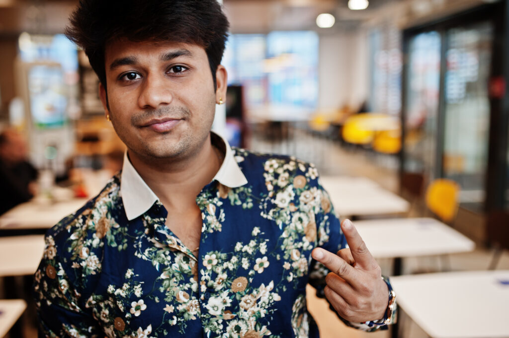 close up portrait of young male indian freelancer in fast food c