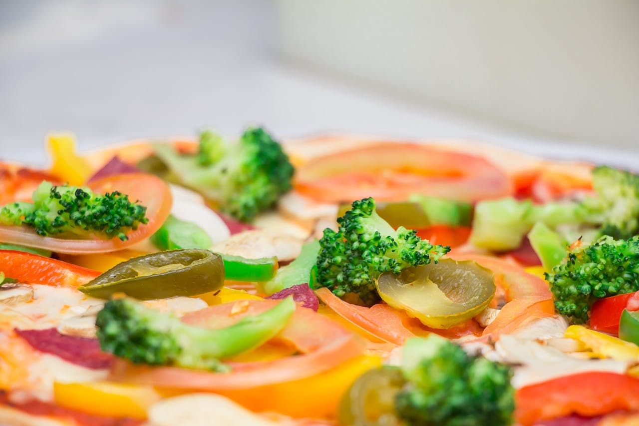 Close-up of a freshly prepared vegetarian pizza topped with colorful vegetables.